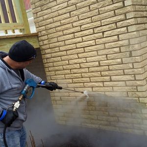 Photo of a brick chimney being power washed