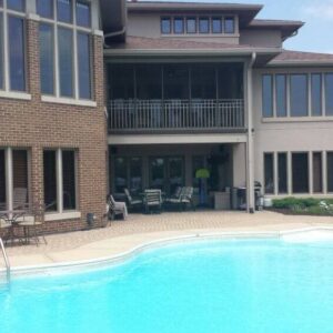 Photo of the back of a house with a pool and a paver pool deck