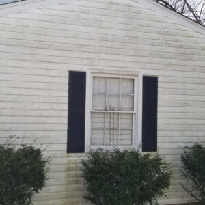 Photo of the side of a house with window and white vinyl siding ready to be cleaned