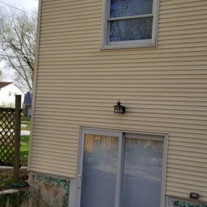Photo of a home with light tan vinyl siding that was recently power washed and restored